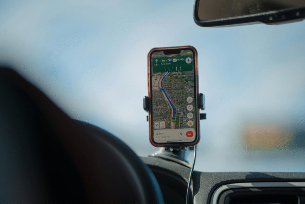 Smartphone mounted on a car dashboard displaying a GPS navigation app rerouting around traffic